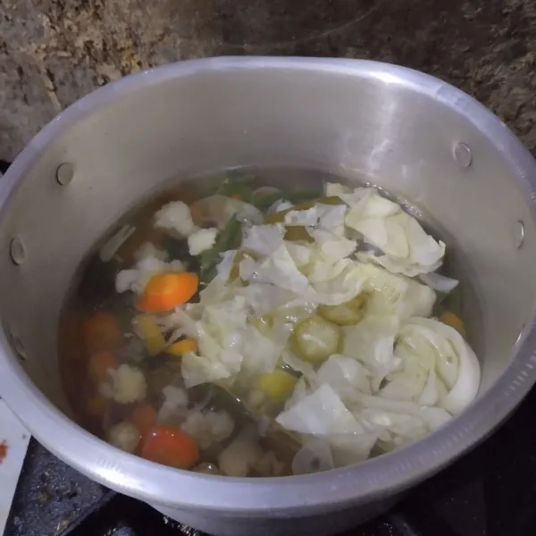 Tambahkan kol, belimbing sayur, garam dan kaldu bubuk.