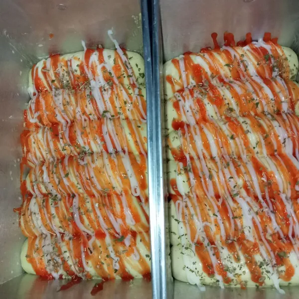 Letakkan adonan di dalam loyang yang sudah diolesi dengan margarin, resting selama 20 menit hingga mengembang lalu semprotkan saus tomat dan mayonaise di atasnya. Kemudian taburi dengan oregano dan parsley.