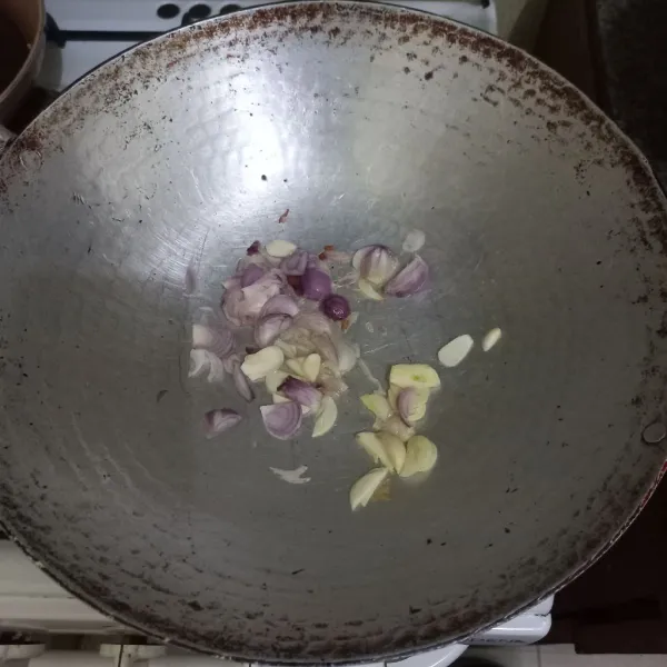 Tumis irisan bawang merah dan bawang putih hingga harum.