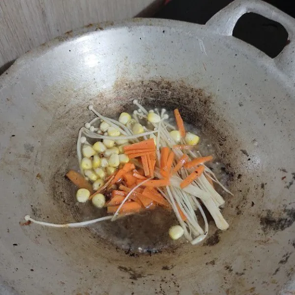 Masukkan jagung, wortel dan jamur enoki, masak hingga sayurnya matang, masukkan air dan rebus hingga sayur empuk.