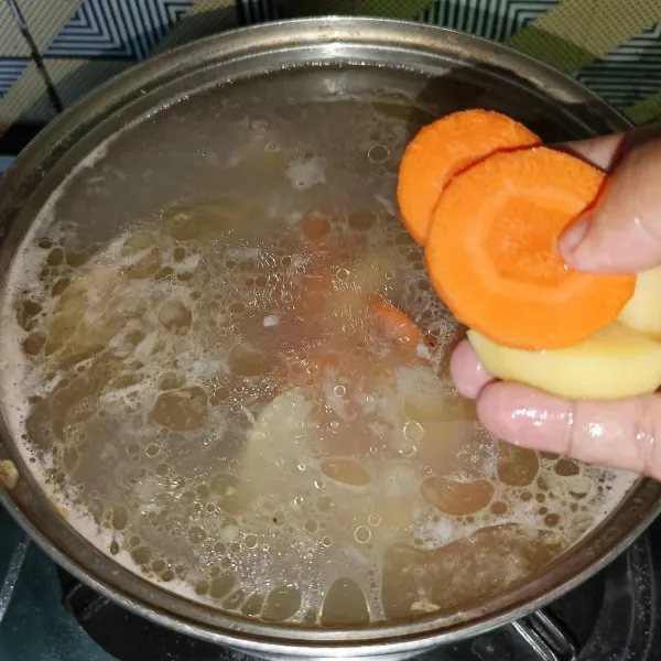 Tambahkan potongan kentang dan wortel.