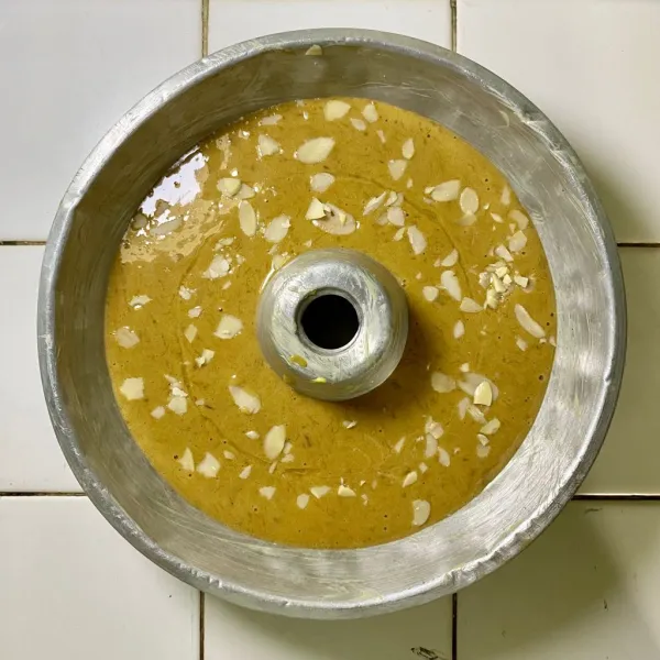 Olesi loyang dengan margarin, lalu tambahkan topping almond slice.