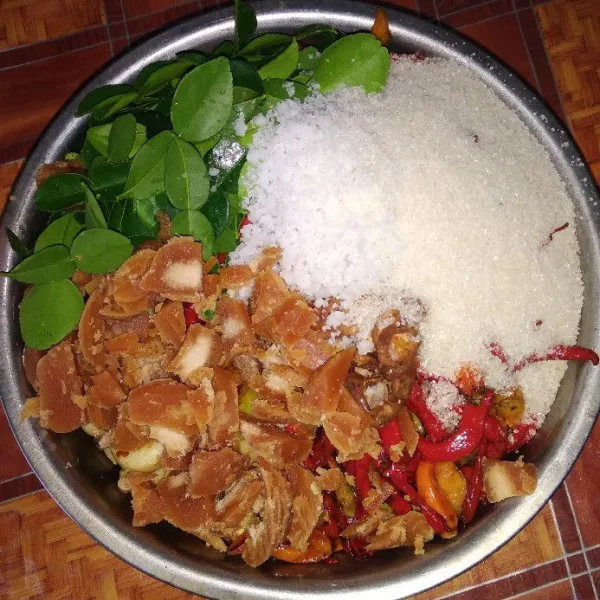 Taruh dalam wadah besar, masukkan kacang goreng, bawang dan cabe goreng, daun jeruk, kencur, asam jawa, gula merah yang sudah disisir, gula pasir dan garam. Siap dibawa ke penggilingan sambal untuk dihaluskan menjadi sambal.