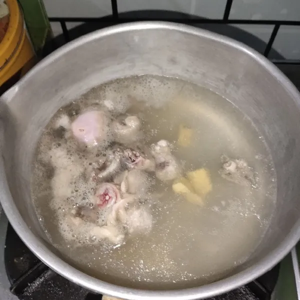 Panaskan air kemudian rebus ayam dan beri jahe.