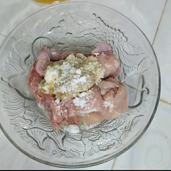 Tuang bumbu halus wadah berisi ayam.