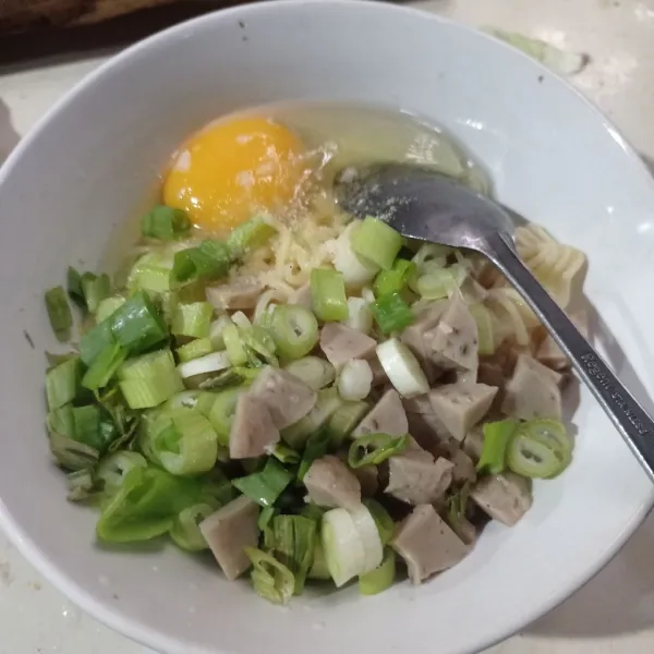 Masukkan telur, daun bawang, bakso, garam, lada, dan kaldu bubuk ke dalam mangkuk. Aduk rata.