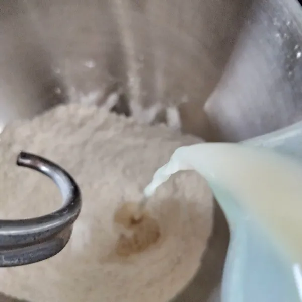 Masukkan tepung terigu dan maizena ke dalam bowl, lalu campurkan gula pasir dan baking powder. Uleni sambil masukkan campuran air ragi.
