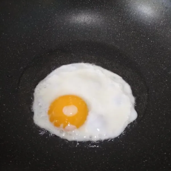 Panaskan minyak, goreng telur, masak telur sesuai selera untuk tingkat kematangannya. Sajikan nasi goreng dengan telur ceplok dan kerupuk.