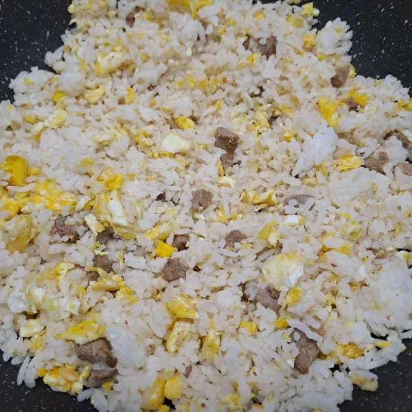 Masukkan nasi putih, aduk rata dengan tumisan. Bumbui kecap asin, merica bubuk dan garam. Aduk rata sambil koreksi rasa sesuai selera.