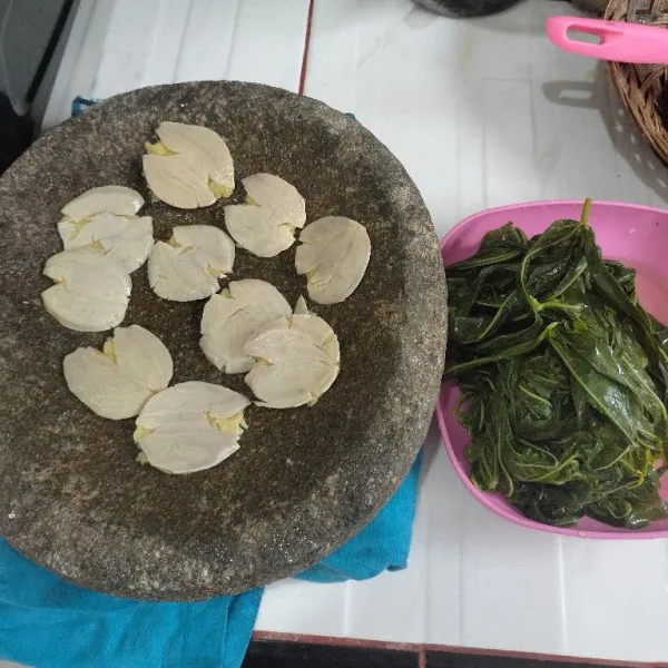 Rebus daun singkong hingga setengah matang, belah dua jengkol lalu rebus hingga matang lalu di geprek pelan.