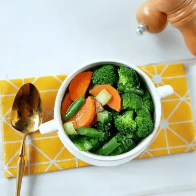 Sup brokoli dengan wortel, kacang panjang, dan alat makan