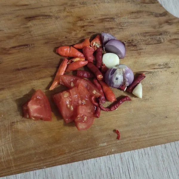Potong bawang merah, bawang putih, cabe rawit, cabe keriting dan tomat dengan ukuran lebih kecil agar menguleknya mudah.