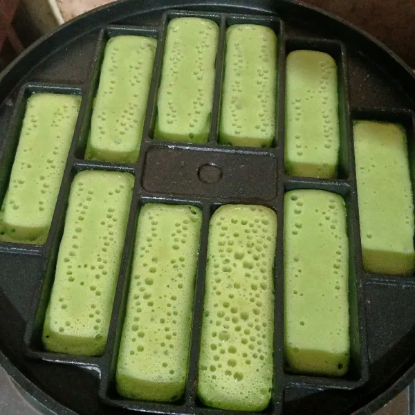Panaskan cetakan, oles margarin. Tuang adonan hingga 3/4 tinggi lubang cetakan. Panggang setengah matang.