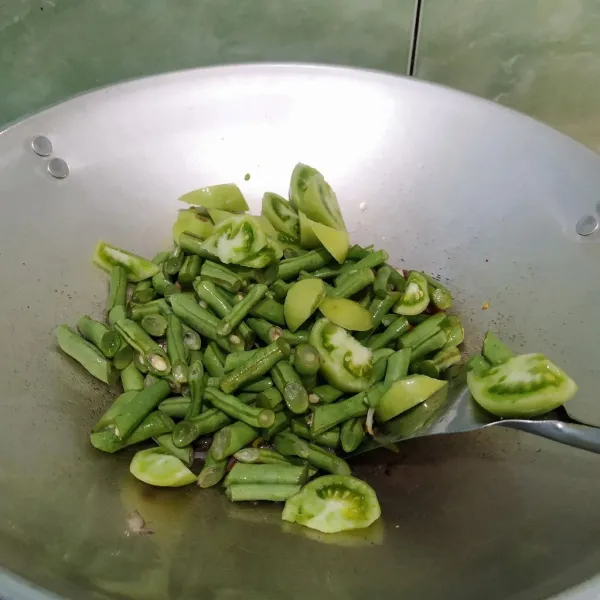 Masukkan buncis dan timat hijau, tumis hingga layu.