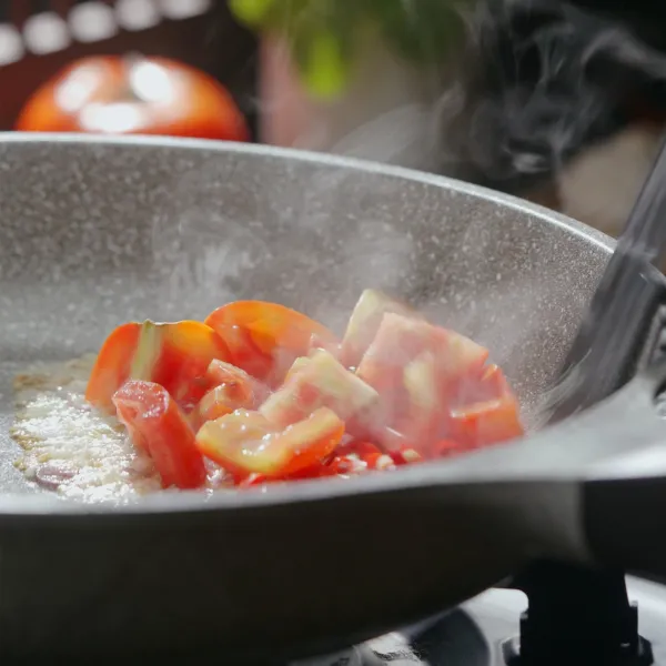 Tumis bawang putih dan bawang merah hingga harum, lalu masukkan tomat dan juga cabai merah masak hingga layu.