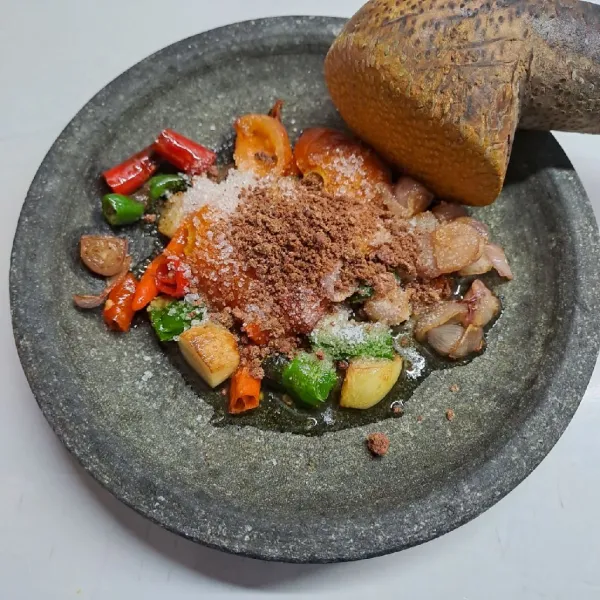 Letakkan di cobek, beri terasi matang, garam dan gula pasir. Uleg sampai halus sambil koreksi rasa sesuai selera. Sajikan sambal dengan ikan dori goreng.