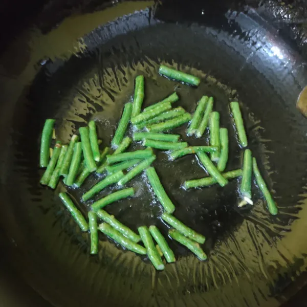 Tumis kacang panjang hingga setengah matang.