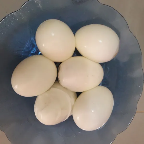 Rebus telur hingga matang kemudian kupas.