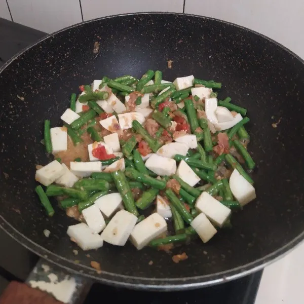 Masukkan kacang panjang dan irisan putih telur. Tambahkan sedikit air lalu masak hingga kacang panjangnya setengah matang.
