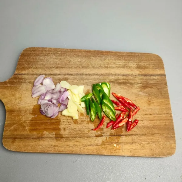 Iris tipis bawang merah, bawang putih, cabe merah, dan cabe hijau.