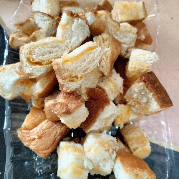 Potong dadu pinggiran roti tawar.