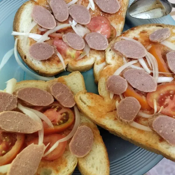 Tambahkan irisan sosis dan bawang bombay.