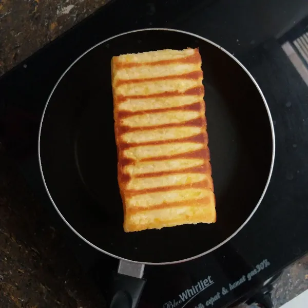 Panaskan teflon, panggang roti di setiap sisinya hingga berwarna kecoklatan.