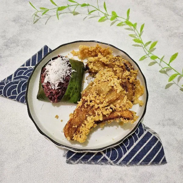 Kemudian tata juga pisang goreng keatas piring saji, lalu taburi kelapa parut diatas ketan hitam. Kemudian sajikan hangat.