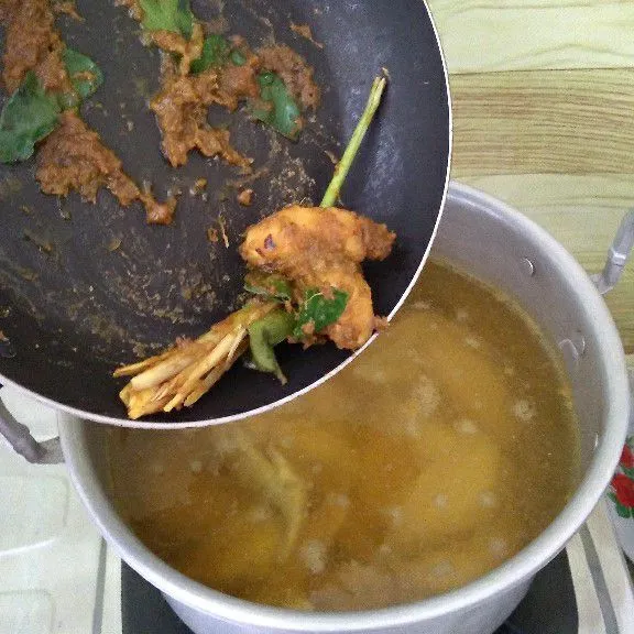 Masukkan bahan bumbu ke rebusan ayam lalu aduk.