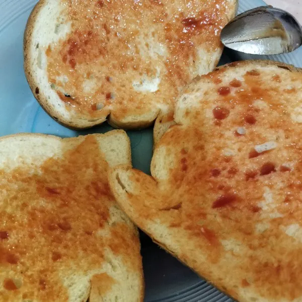 Olesi roti tawar dengan saus tomat.