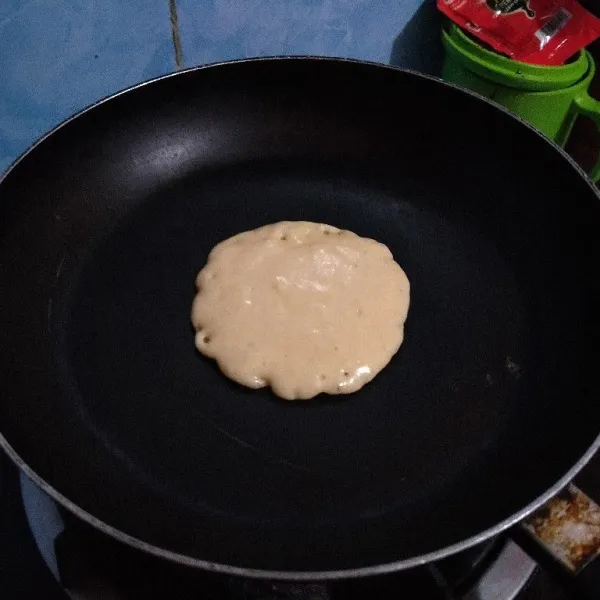 Panaskan pan anti lengket, usap tipis dengan minyak. Tuang 1 centong sendok sayur ke dalam pan.