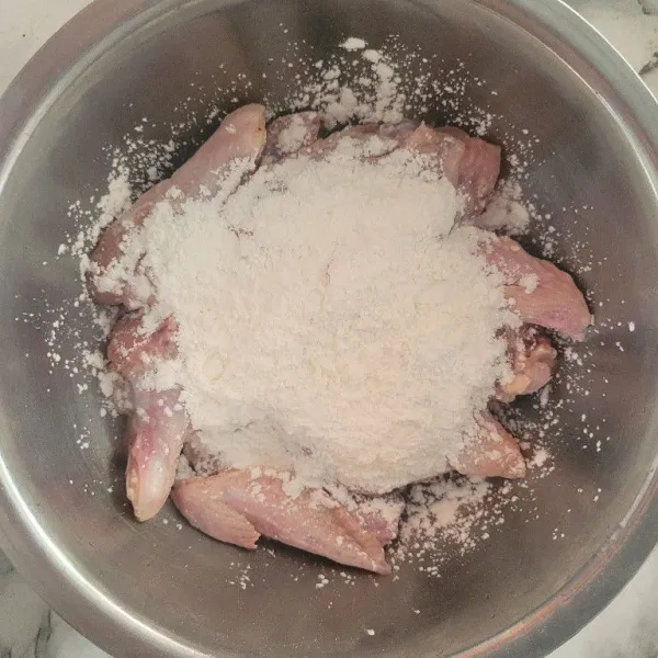Lumuri ayam dengan tepung maizena hingga rata.