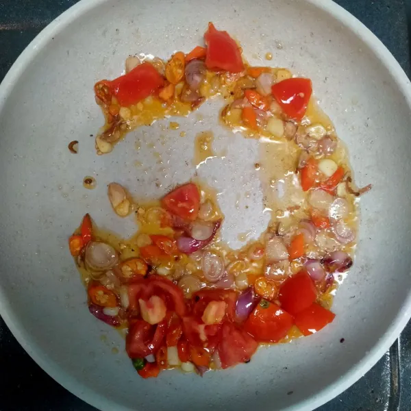 Panaskan minyak tumis irisan bawang merah, bawang putih, cabe rawit dan tomat.