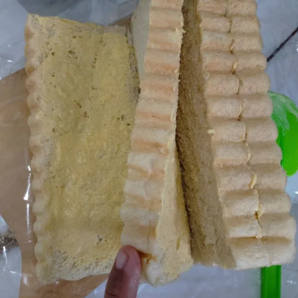 Beri olesan margarin di setiap lapisan roti.