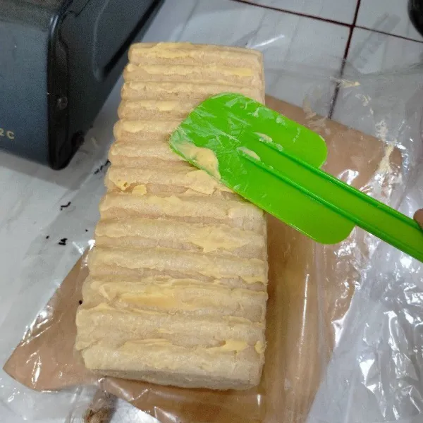 Lipat lapisan roti lali beri olesan margarine di sisi luar roti.