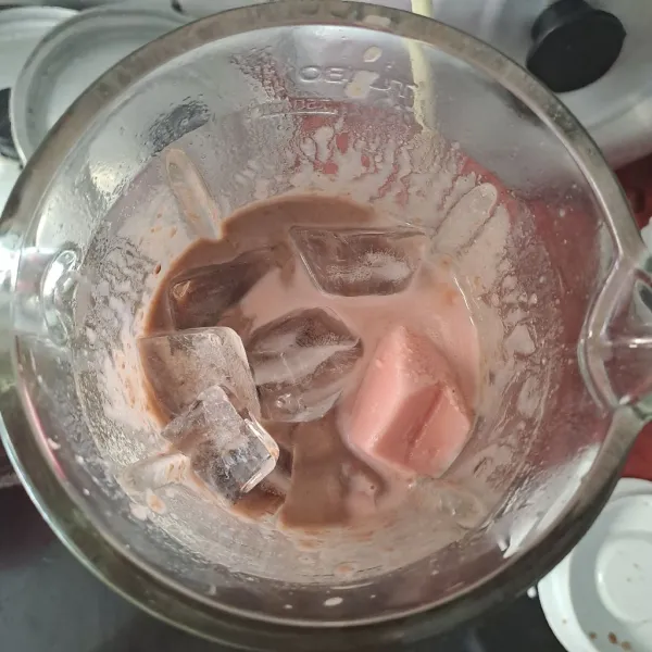 Masukkan susu strawberry yang sudah dibekukan dan 9 cup es batu. Blender hingga menyatu.