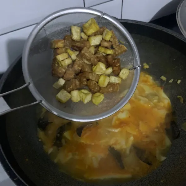 Goreng tahu dan tempe tuang ke wajan.