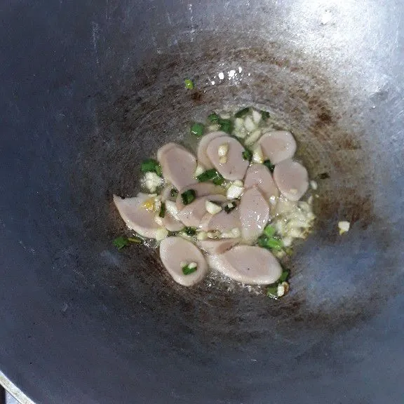 Panaskan satu sendok minyak, tumis bawang putih dan daun bawang sampai harum, masukan sosis, lanjut sampai sosis matang .