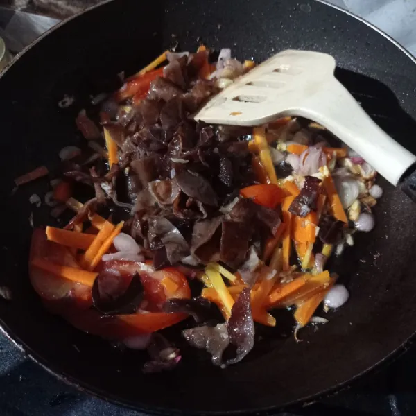 Tambahkan wortel, kol, dan jamur kuping. Aduk rata kemudian masak sampai layu.