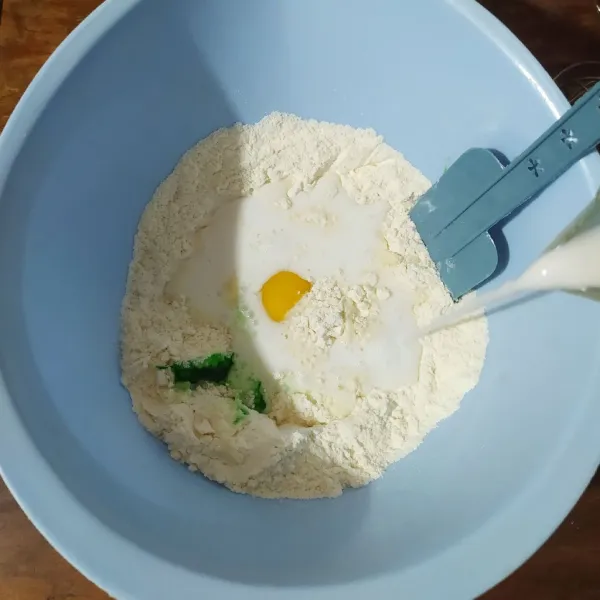 Masukkan telur, santan dan pasta pandan, kocok dengan whisk sampai gula larut.