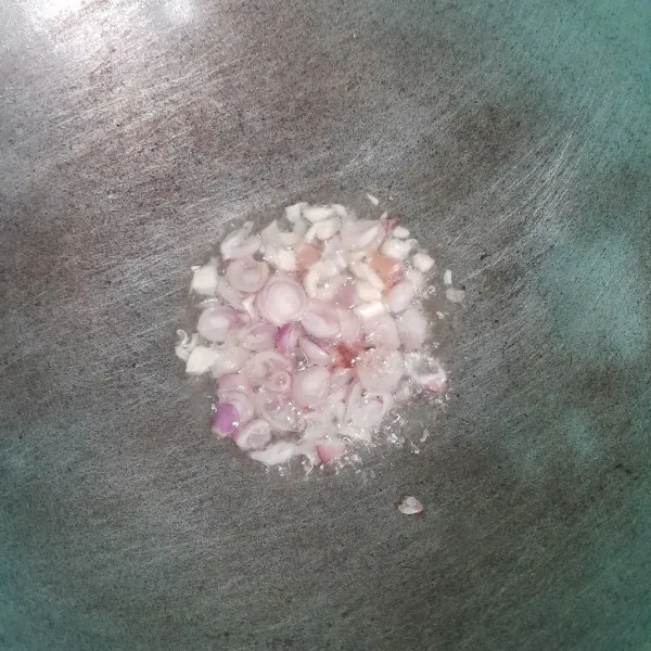 Goreng bawang merah dan bawang putih sampai harum.