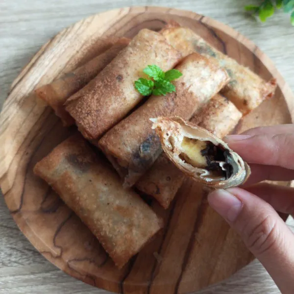 Sajikan lumpia pisang cokelat dengan diberi taburan cinnamon.