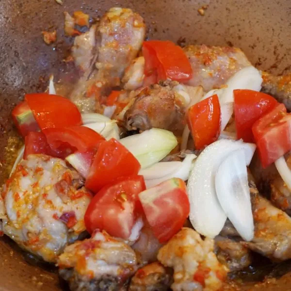 Masukkan ayam dan tambahkan bawang bombay dan tomat.