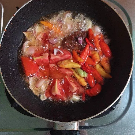 Tambahkan cabe dan tomat, goreng hingga masak.