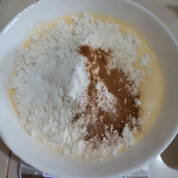 Selanjutnya masukkan sambil disaring tepung, baking powder, baking soda, kayu manis bubuk dan coklat bubuk.
