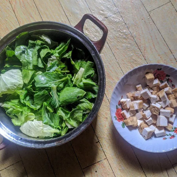 Cuci bersih sawi dan potong potong tahu.