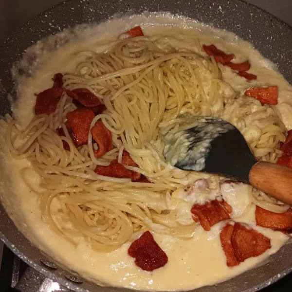 Masukkan spaghetti dan sosis, aduk sampai tercampur rata. Cek rasa dan matikan api.