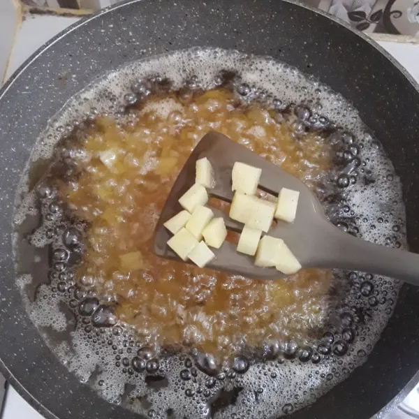Goreng kentang dalam minyak panas sampai matang.