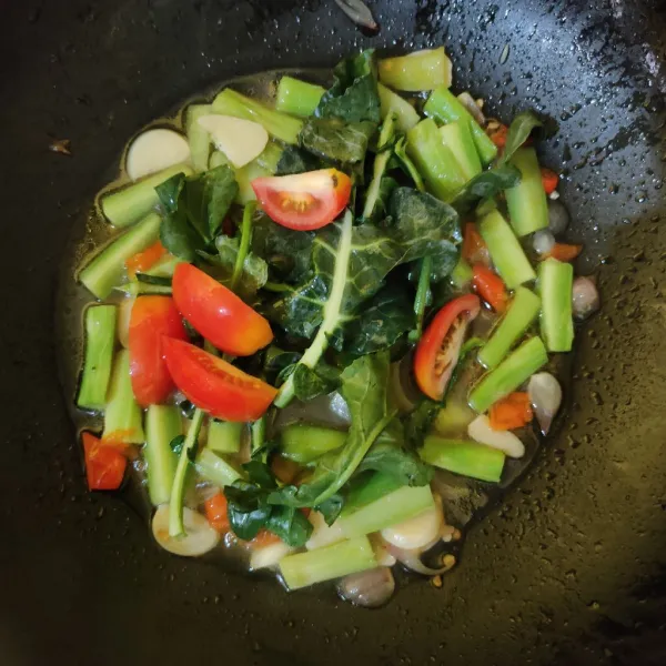 Masukkan daun brokoli dan tomat, aduk rata.