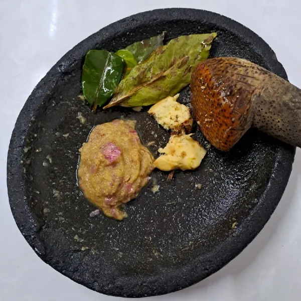 Uleg bahan bumbu halus. Geprek lengkuas, siapkan daun salam dan daun jeruk.